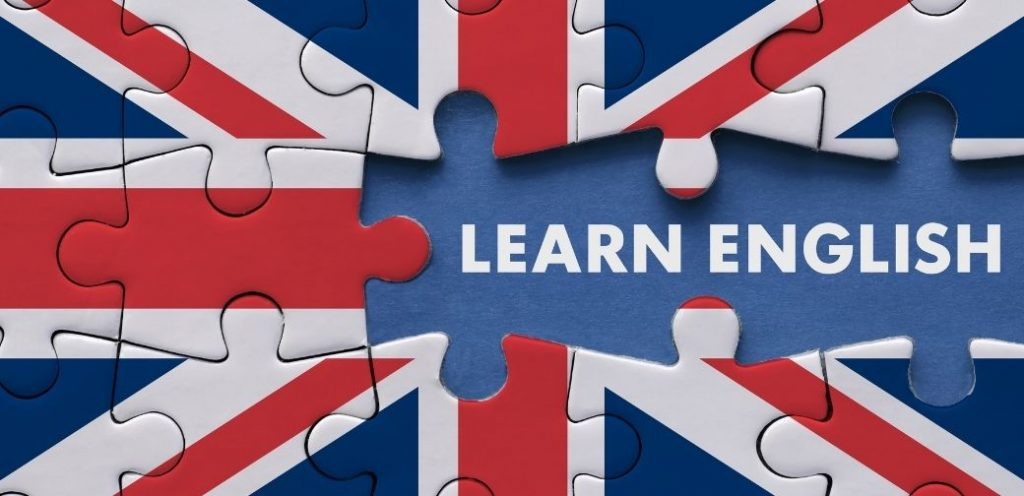 Puzzle z flagą Wielkiej Brytanii, z napisem 'Learn English' w niebieskiej przestrzeni. Koncepcja nauki języka angielskiego.