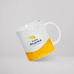 ALFABET MARKI SPÓŁKA Z OGRANICZONĄ ODPOWIEDZIALNOŚCIĄ - Biały kubek z nadrukiem logo i napisem 'Gmina Płużnica. Pole możliwości' na jasnoszarym tle.