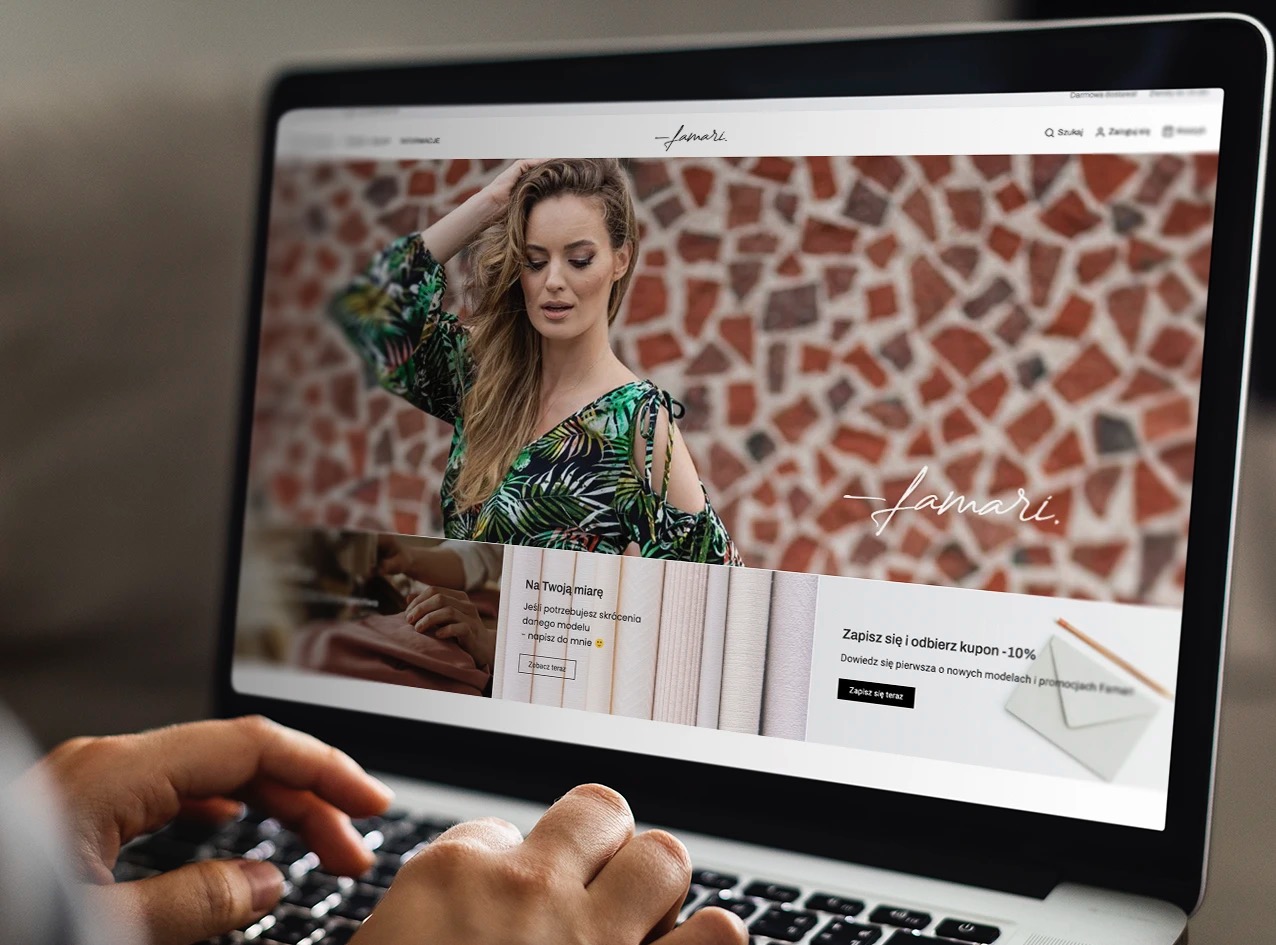 Ekran laptopa wyświetlający stronę internetową sklepu odzieżowego 'Famari' z modelką w tropikalnej sukience na tle mozaiki z cegieł, dłonie osoby piszą na klawiaturze.