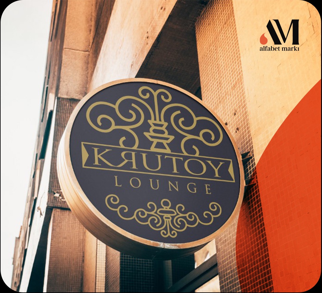 Okrągły szyld z logo 'KAUTOY Lounge' w kolorze złotym na ciemnoniebieskim tle, zamontowany na elewacji budynku z jasnego kamienia.