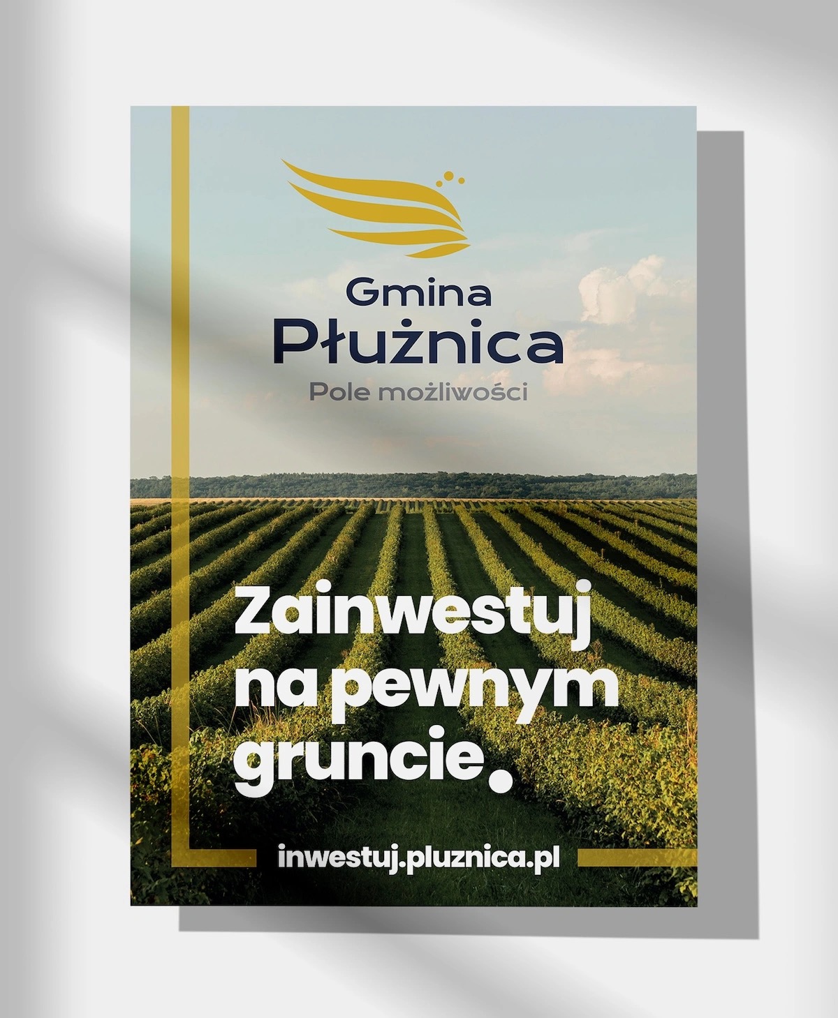 Plakat reklamowy Gminy Płużnica z motywem krajobrazu rolniczego i hasłem 'Zainwestuj na pewnym gruncie.'