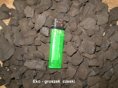 Kupa ciemnego ekogroszku czeskiego z zieloną zapalniczką na wierzchu dla skali.