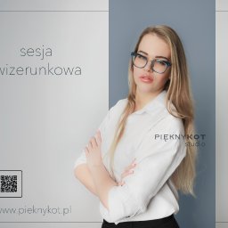 Alicja Kopiec - Portret kobiety w okularach we Wrocławiu, z założonymi rękami na tle minimalistycznego studia z logo i kodem QR.