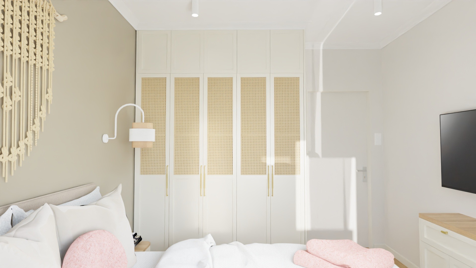 Jasna sypialnia z dużym łóżkiem, szafą z rattanowymi wstawkami i dekoracyjnym makramem na ścianie. Minimalistyczny design, ciepłe oświetlenie.