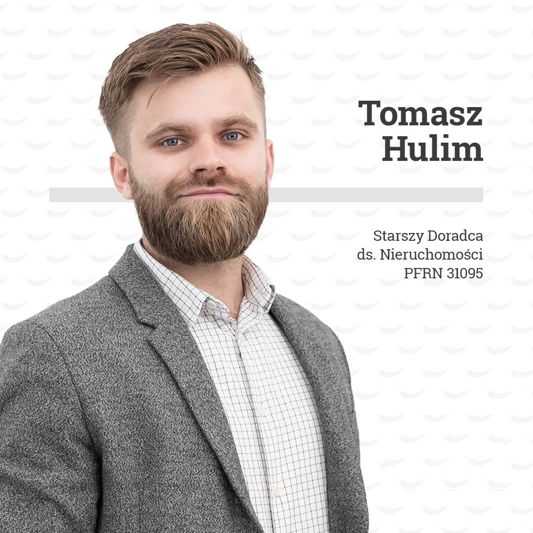 Portret Tomasza Hulima, starszego doradcy ds. nieruchomości z numerem PFRN 31095, w szarej marynarce i białej koszuli w kratkę, na jasnym tle z delikatnym wzorem.