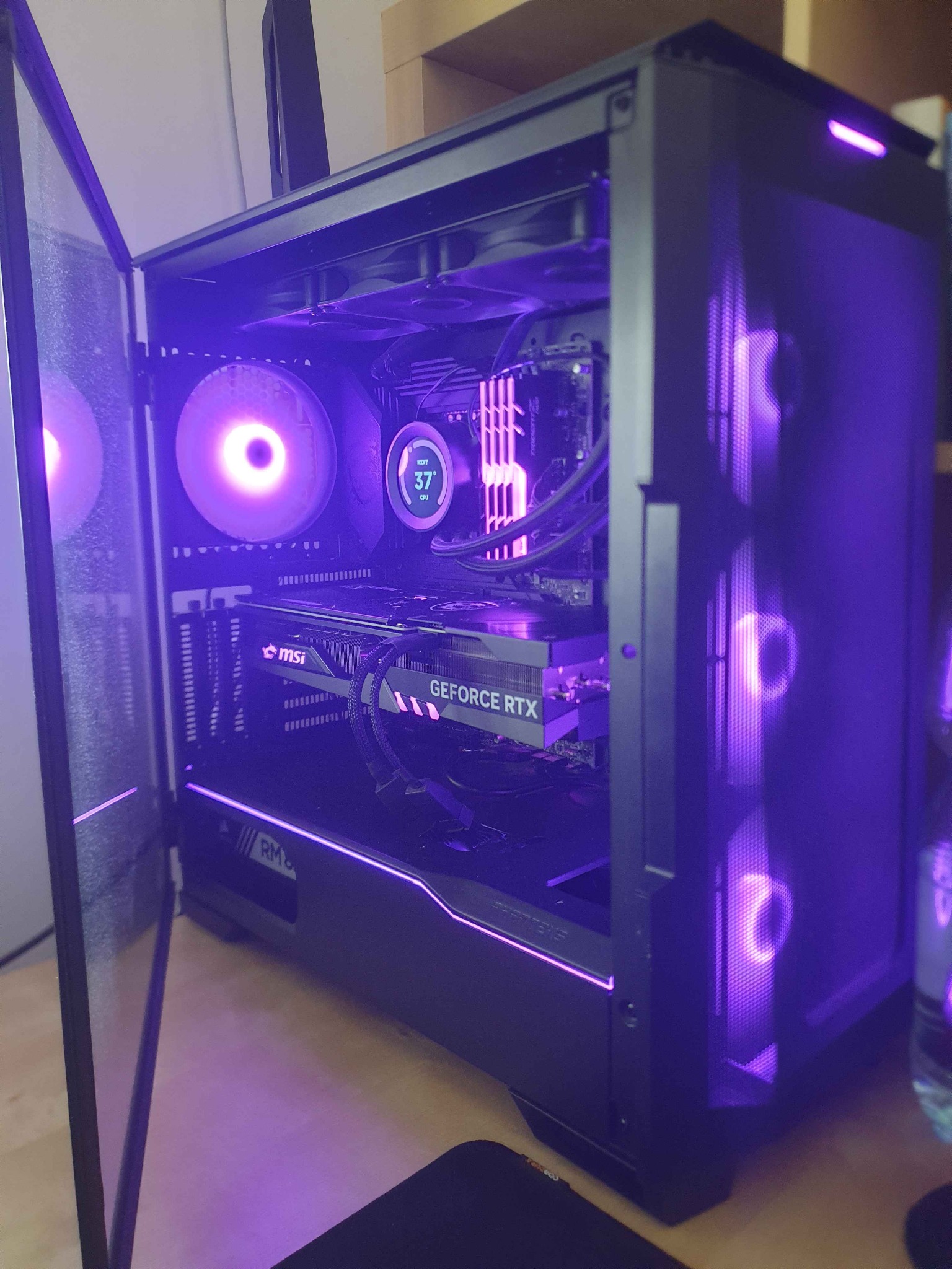 Otwarta obudowa komputera PC z podświetleniem RGB, widoczne komponenty: karta graficzna MSI GeForce RTX, chłodzenie procesora, wentylatory. Estetyczne wnętrze gamingowego PC.