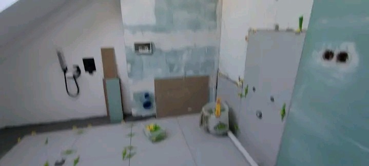 Łazienka w trakcie układania płytek pod skosem, widoczne narzędzia i materiały budowlane. Ściany przygotowane do dalszych prac wykończeniowych.