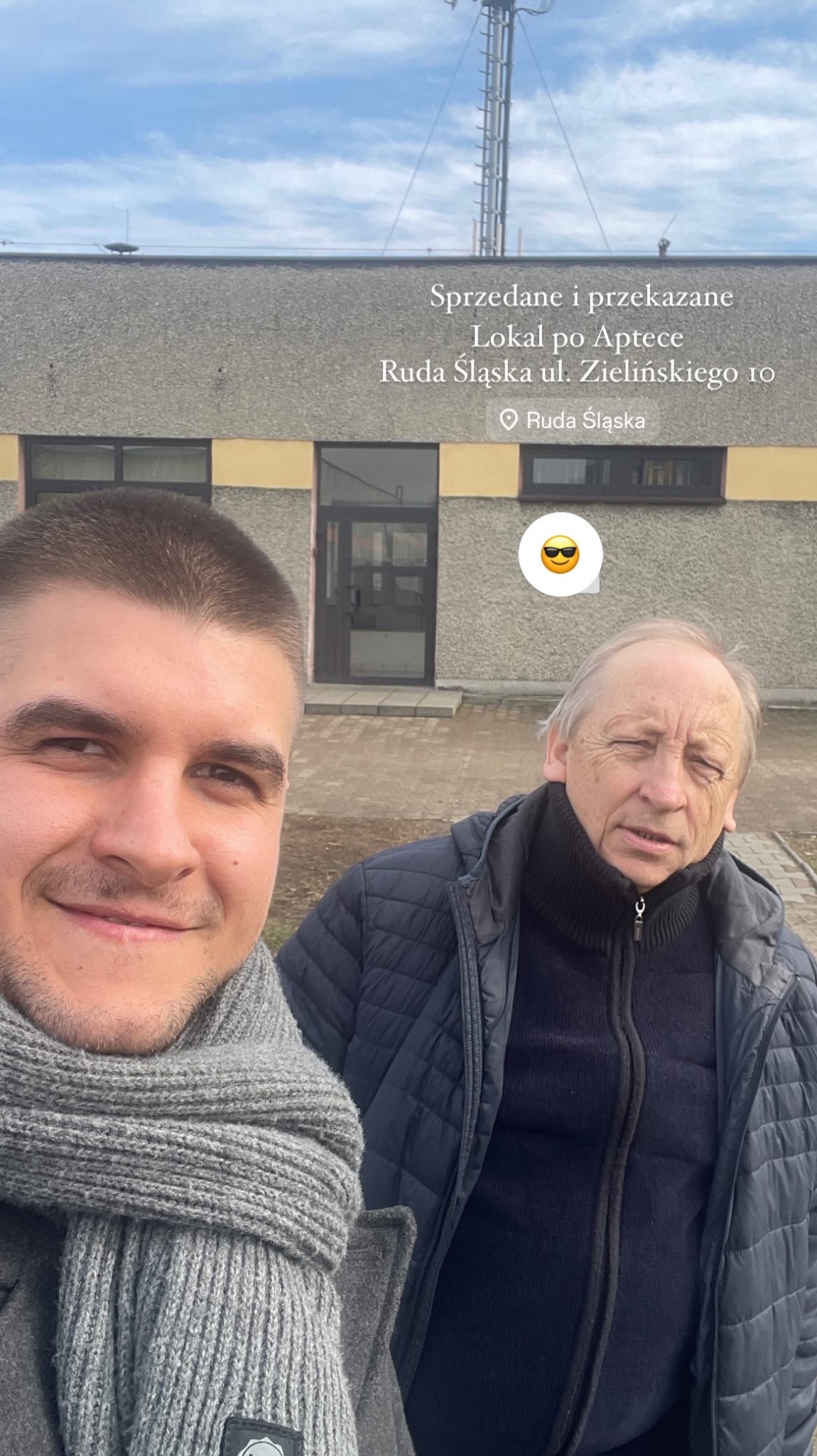 Selfie dwóch mężczyzn na tle budynku z napisem 'Sprzedane i przekazane. Lokal po Aptece. Ruda Śląska'.