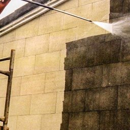 URBAN ALPSERWIS SPÓŁKA Z OGRANICZONĄ ODPOWIEDZIALNOŚCIĄ - Czyszczenie elewacji budynku z kamienia za pomocą myjki ciśnieniowej. Widoczna różnica między umytą a zabrudzoną powierzchnią.