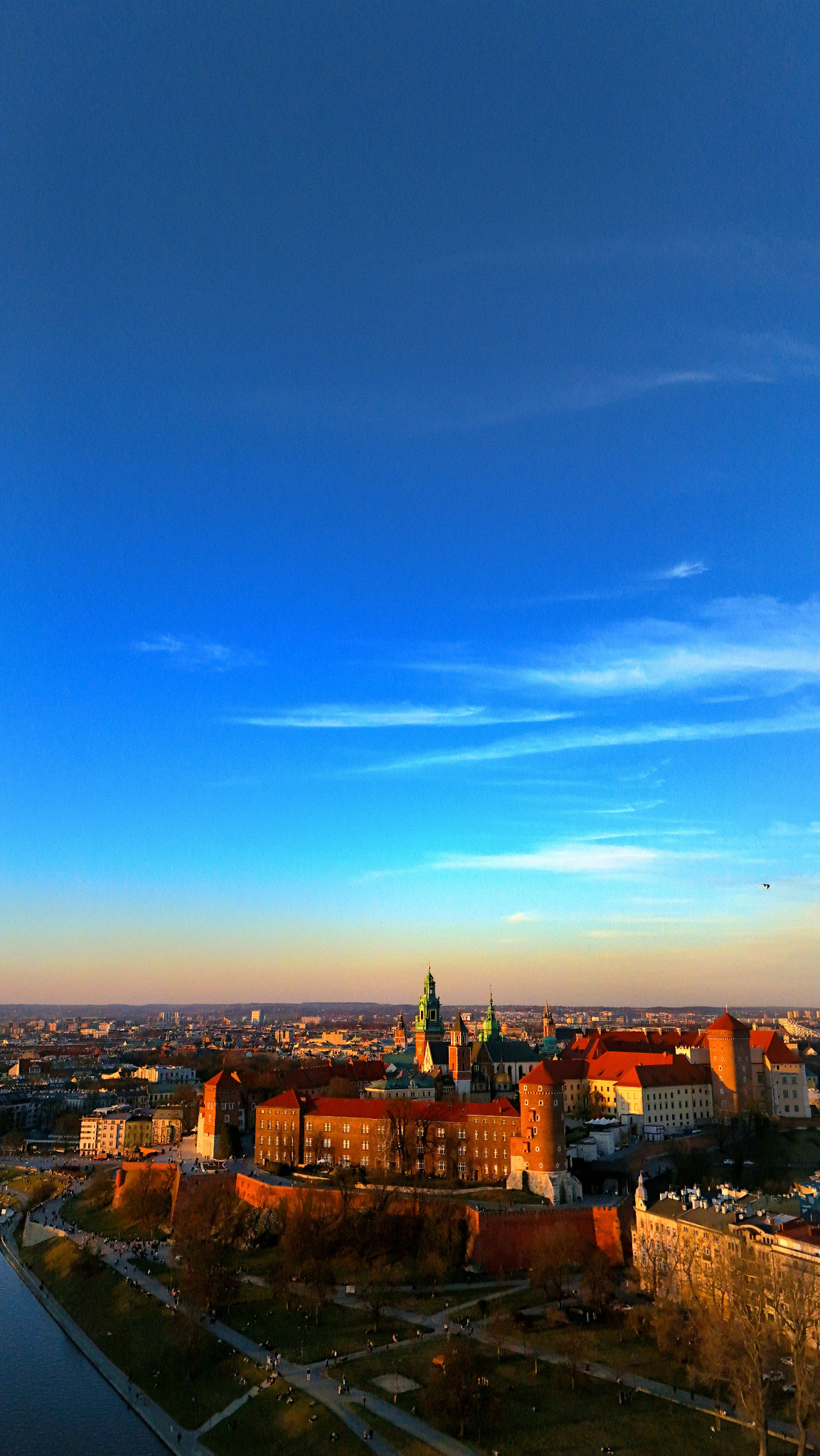 Panorama Krakowa z Wawelem w promieniach zachodzącego słońca, widok z lotu ptaka na Stare Miasto i zakole Wisły.