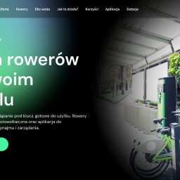 Strony internetowe & marketing - VNEA - Stacja ładowania rowerów elektrycznych z zielonymi rowerami, umieszczona pod zadaszeniem z zieloną ścianą, element oferty dla hoteli.