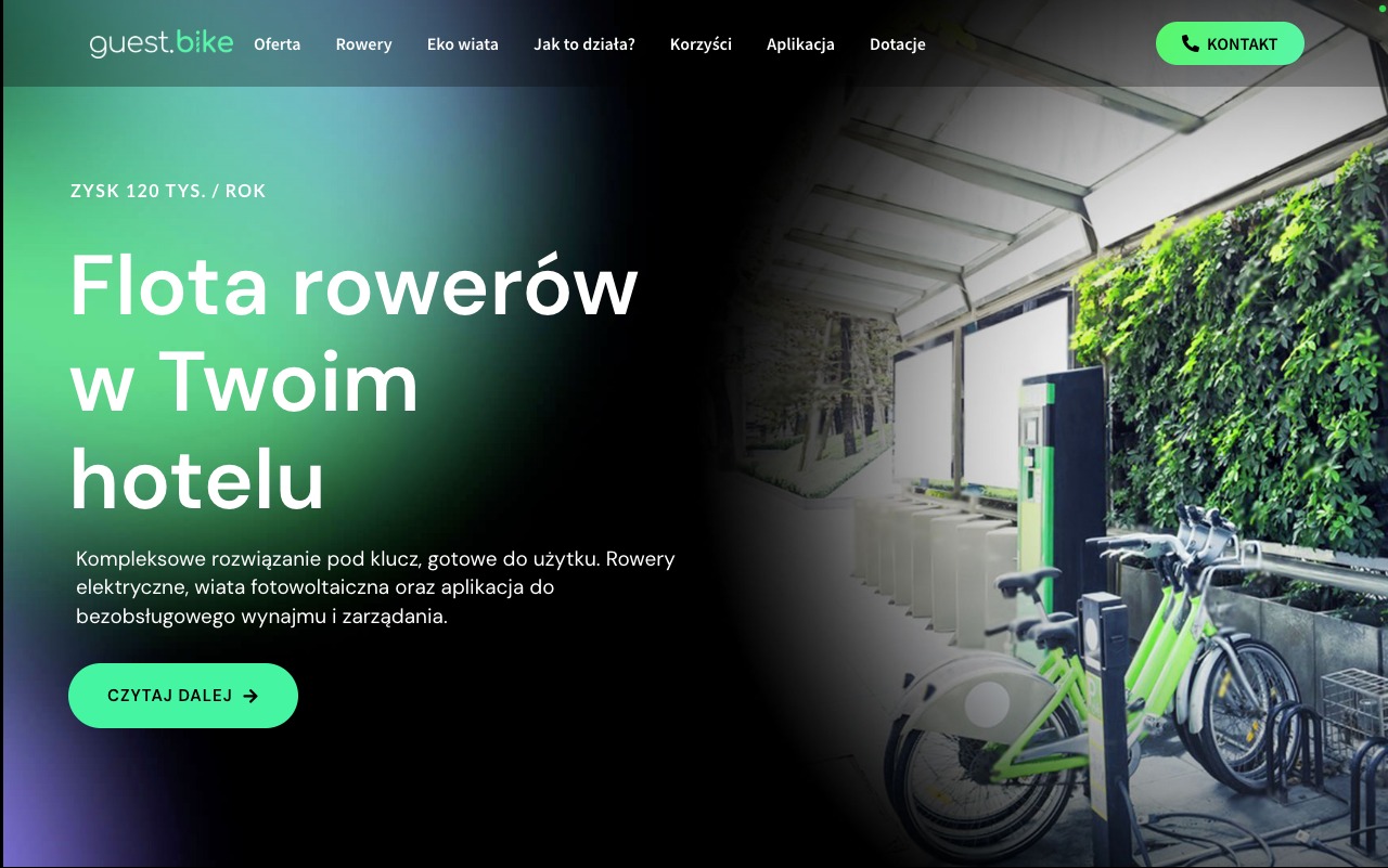 Stacja ładowania rowerów elektrycznych z zielonymi rowerami, umieszczona pod zadaszeniem z zieloną ścianą, element oferty dla hoteli.