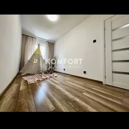 Mazur.s.m - Jasne wnętrze pokoju z drewnopodobną podłogą, dziecięcym tipi i pluszowym słoniem, widoczne listwy przypodłogowe i białe drzwi z poziomymi przeszkleniami.