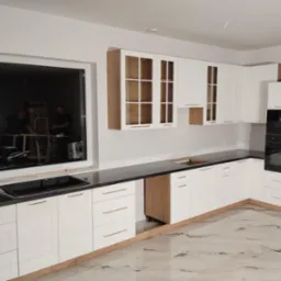 Nowoczesna kuchnia z białymi szafkami, czarnym blatem i marmurową podłogą. W oknie widoczne narzędzia i ekipa montażowa. Górne szafki z elementami drewna.