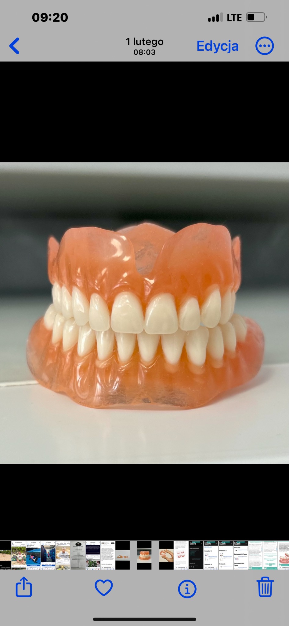 Kompletna proteza zębową na białym tle, widoczne detale różowego akrylu i białych zębów.