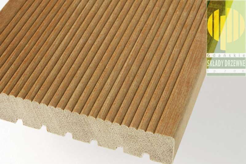 Przekrój deski tarasowej z egzotycznego drewna, widoczne ryflowanie i spodnia struktura z rowkami, w tle logo firmy Gdańskie Składy Drzewne.