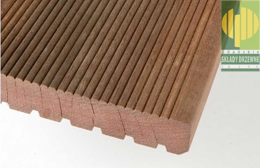Przekrój egzotycznej deski tarasowej z wyraźnie widocznym profilem i logo dostawcy w prawym górnym rogu.