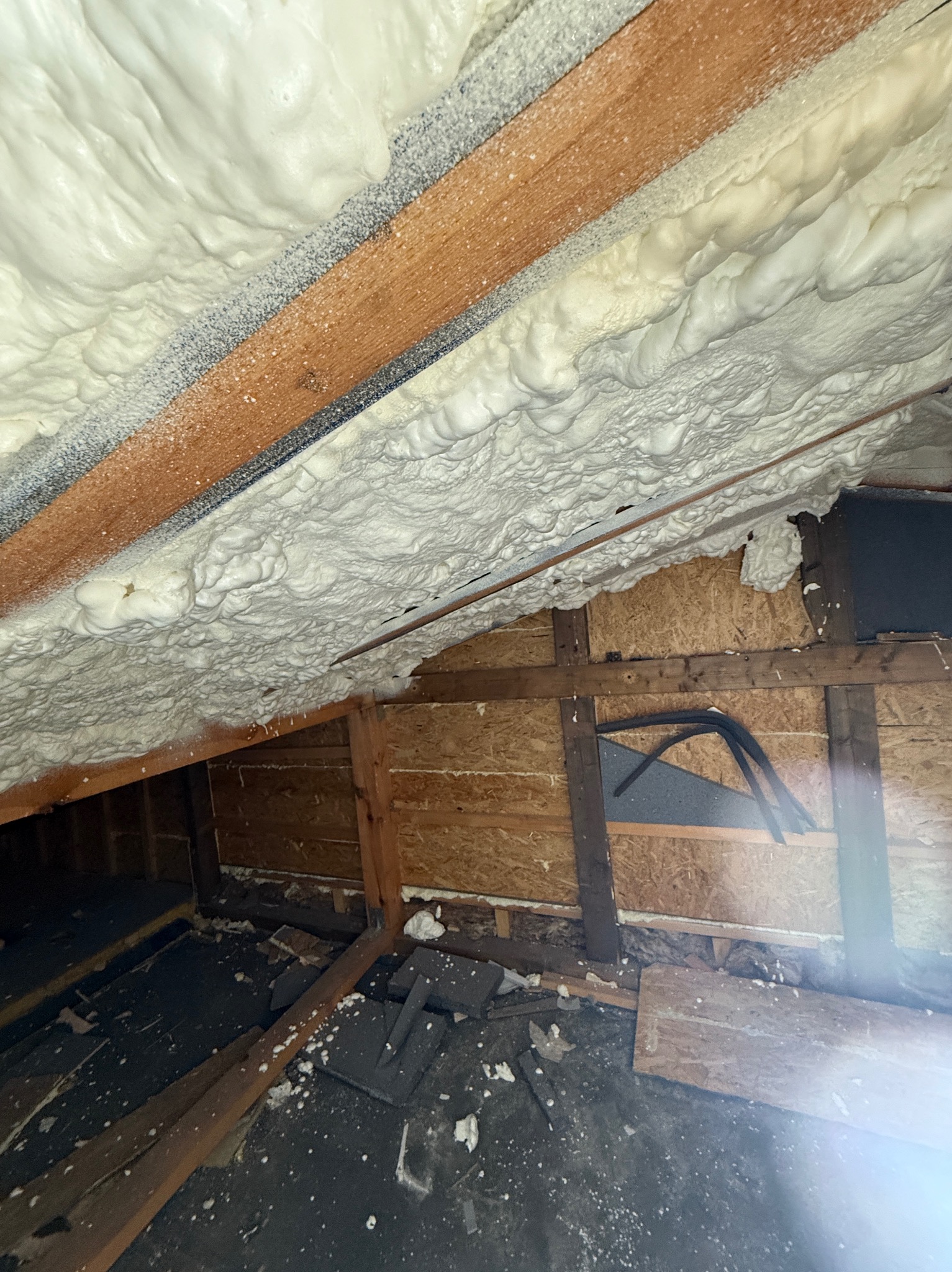 Poddasze po aplikacji izolacji natryskowej w Mieszkowicach. Widoczne drewniane elementy konstrukcyjne i szczelna warstwa piany. Detal wykończenia.