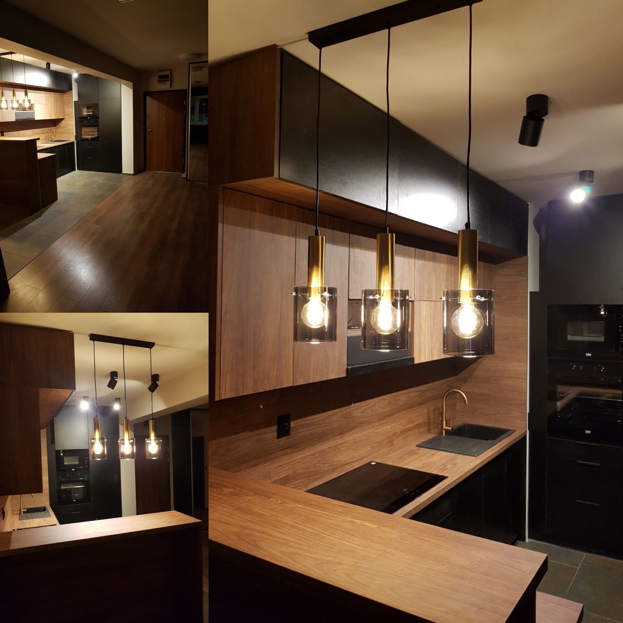 Nowoczesna kuchnia z drewnianymi frontami, czarnymi akcentami i trzema szklanymi lampami wiszącymi nad wyspą kuchenną, widok na zabudowę piekarnika i płytę grzewczą.