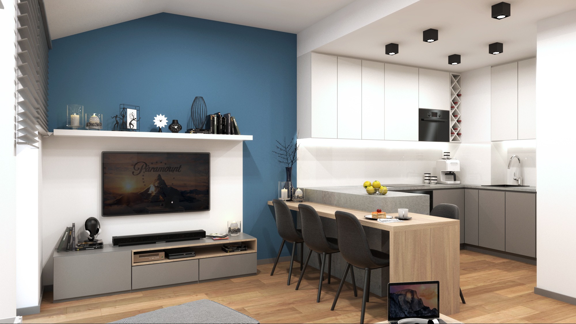Nowoczesna kuchnia z białymi szafkami i szarym blatem, połączona z salonem. Na pierwszym planie wyspa z drewnianym blatem i krzesłami barowymi. Akcent kolorystyczny stanowi błękitna ściana.