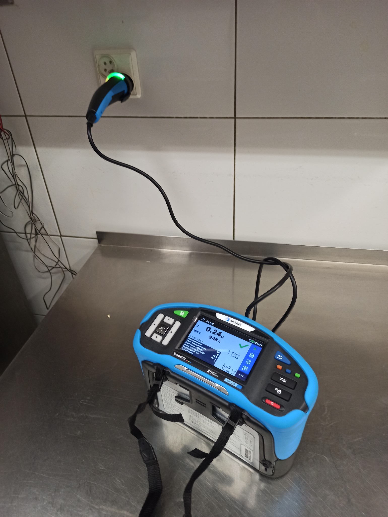 Urządzenie do pomiaru impedancji pętli zwarcia Metrel podłączone do gniazdka elektrycznego w Wejherowie, wskazujące wartość 0.24 oma.