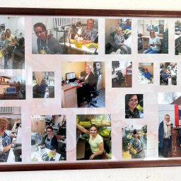 P.P.H.U. Jolanta Leśniak - Oprawiona w ramkę kolaż zdjęć z życia szwalni: pracownicy przy maszynach, gotowe produkty, budynek firmy i właściciele na tle szyldu.