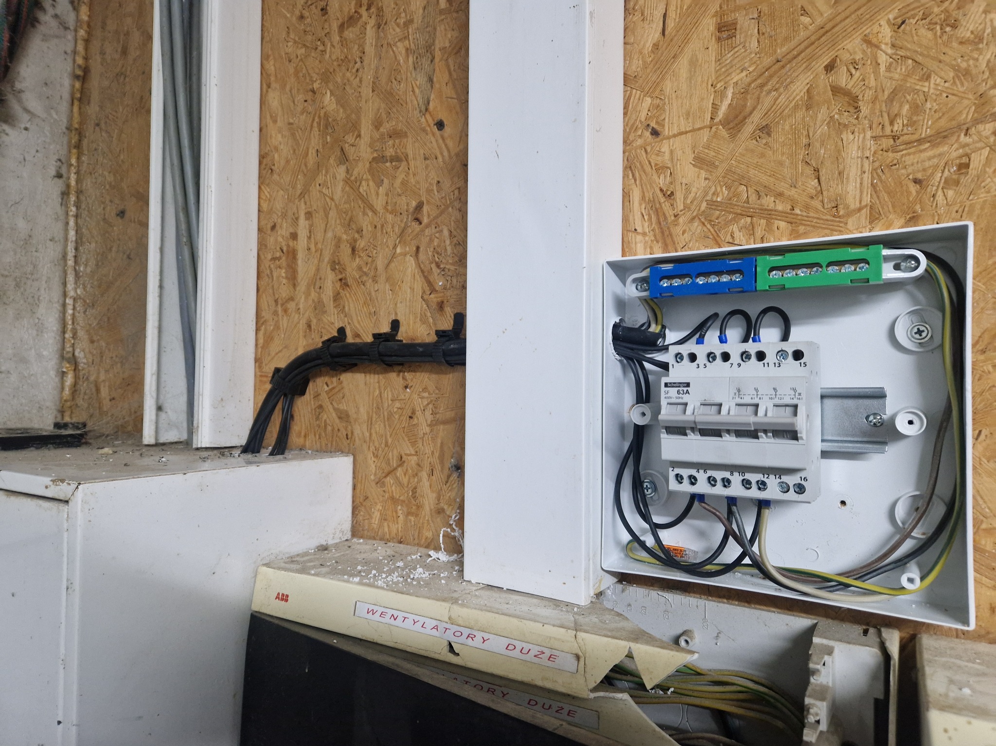 Rozdzielnica elektryczna z zamontowanymi bezpiecznikami i listwami zaciskowymi, widoczna instalacja przewodów elektrycznych w Nowogardzie.