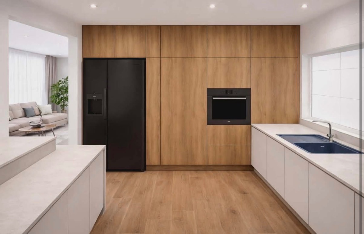 Nowoczesna kuchnia z drewnianymi frontami szafek, czarną lodówką i piekarnikiem. Biały blat i niebieski zlew. Widok na salon z beżową sofą.