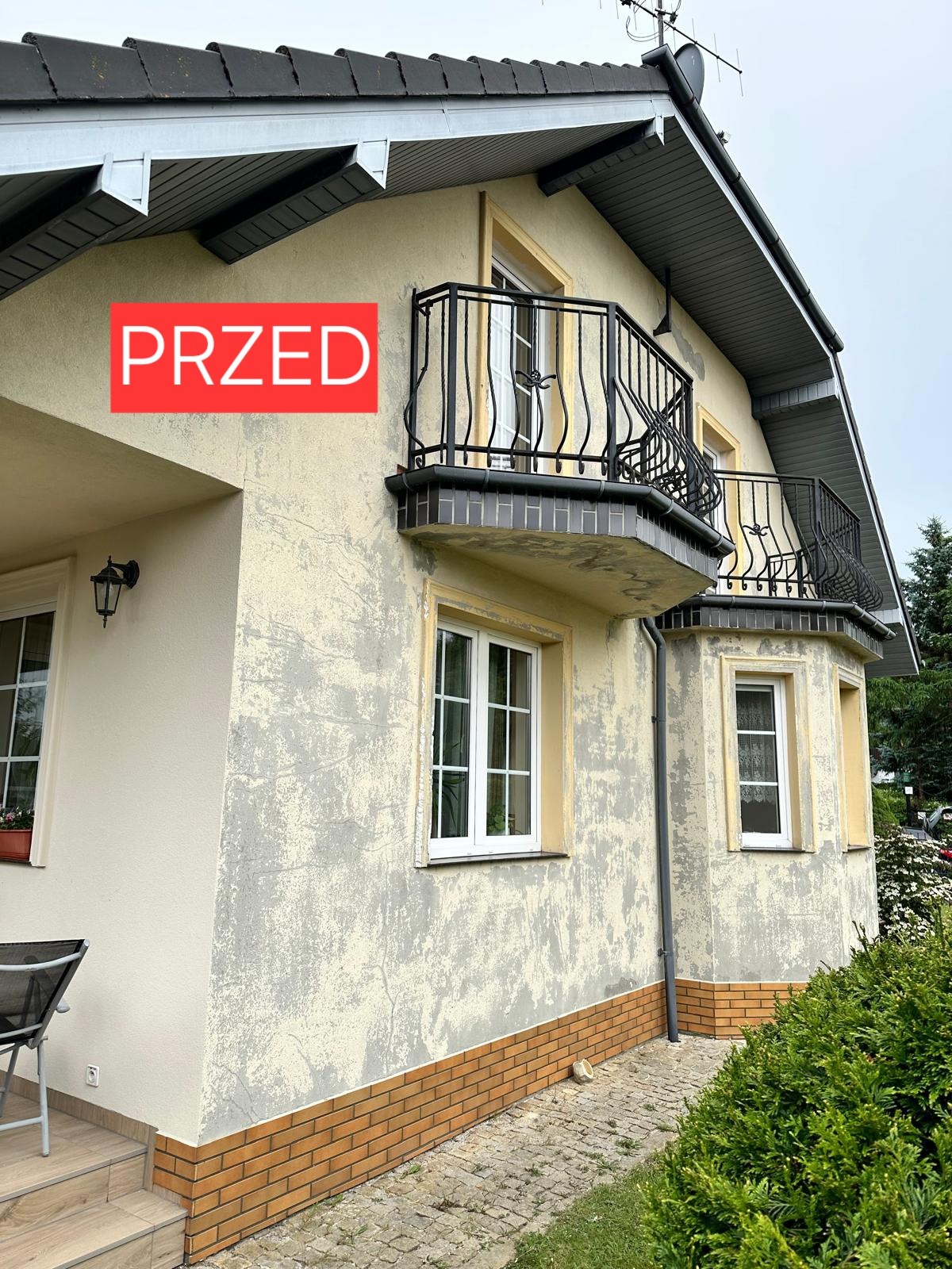 Dom jednorodzinny z balkonami przed odnowieniem elewacji, widoczne uszkodzenia i ubytki tynku, z czerwoną naklejką 'PRZED'.