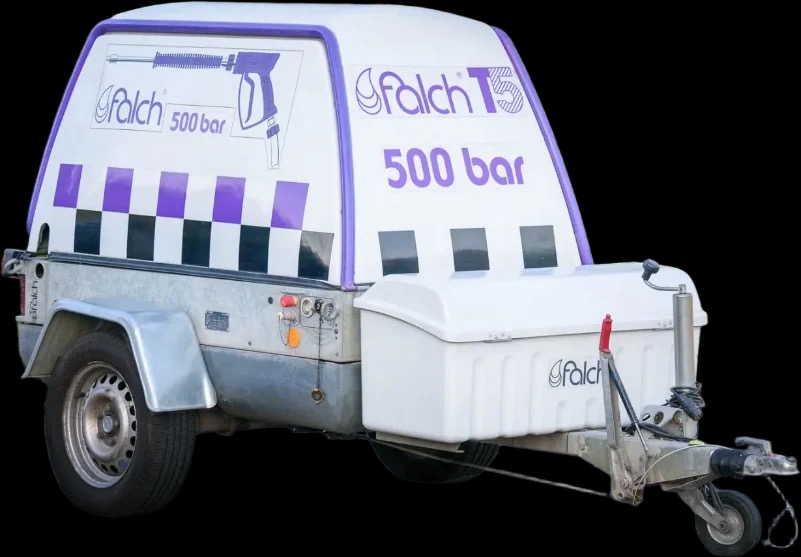 Przyczepa z urządzeniem wysokociśnieniowym Falch T5 500 bar, z widocznym logotypem producenta i motywem szachownicy w kolorach fioletu i czerni, na czarnym tle.