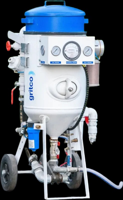 Mobilna piaskarka Gritco z manometrami, zaworami i niebieskim filtrem, stojąca na czarnym tle.
