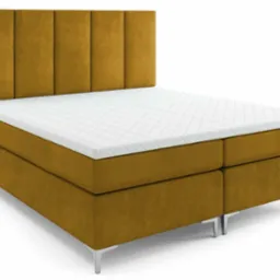 Miodowo-żółte, tapicerowane łóżko kontynentalne z wezgłowiem w pionowe pasy i białym materacem nawierzchniowym, wsparte na smukłych, metalowych nóżkach.