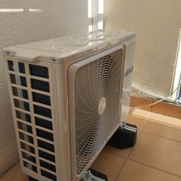 MiAA Budownictwo Mariusz Abramek - Zamontowana jednostka zewnętrzna klimatyzacji HEIKO na balkonie, przymocowana do podłoża za pomocą specjalnych wsporników antywibracyjnych.