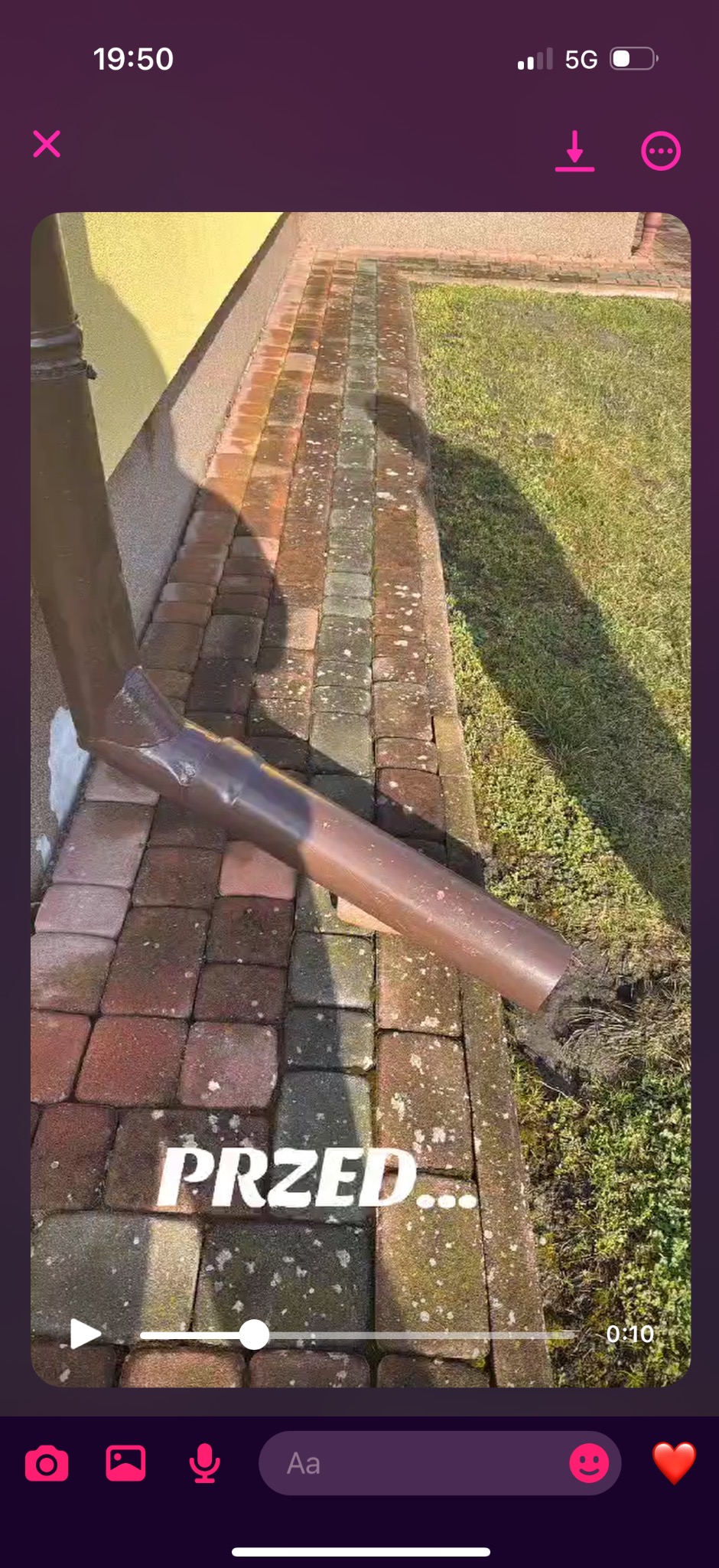 Brudna kostka brukowa przy budynku z widocznym odpływem rynnowym, stan 'przed' czyszczeniem.