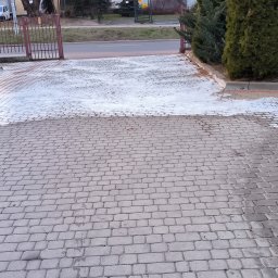 G&G SHOP MARZENA GRYGORUK - Częściowo umyta kostka brukowa przed bramą wjazdową, widoczna różnica w kolorze czystej i brudnej powierzchni.