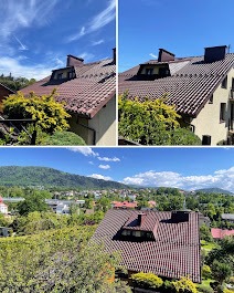 Czerwona dachówka na skośnym dachu domu z widokiem na góry i błękitne niebo. Ujęcie z góry, pokazujące detale dachu i otoczenie.