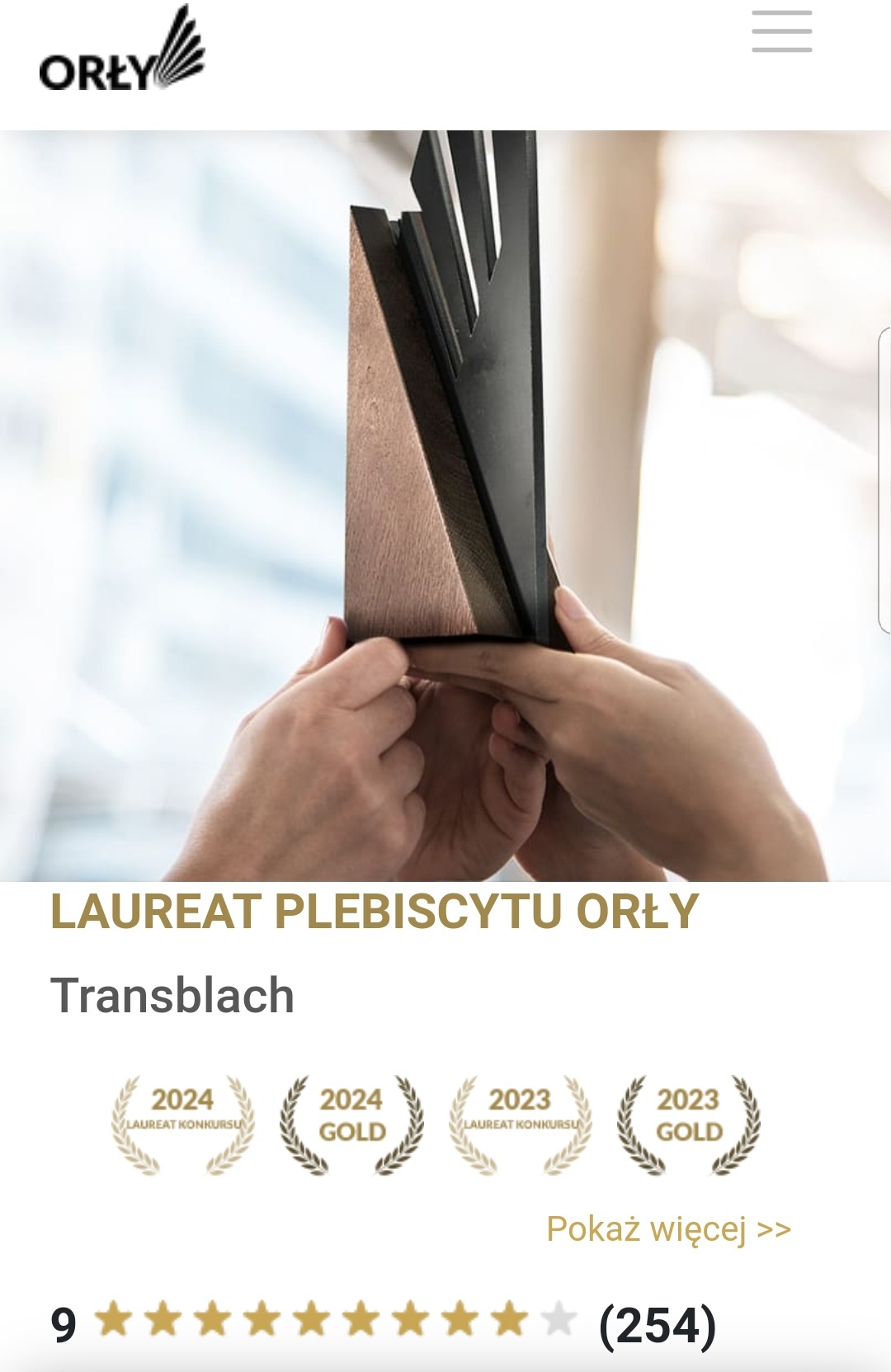 Dłonie trzymające próbkę przekroju dachu z czarnym wykończeniem, prezentacja produktu Transblach, laureat plebiscytu Orły.