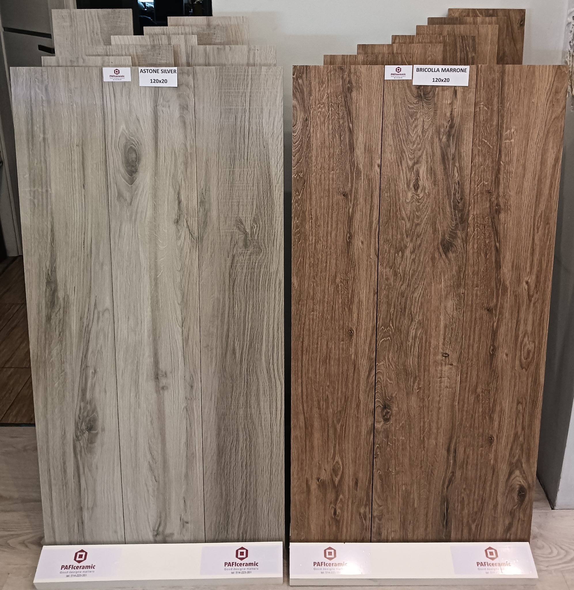Prezentacja dwóch rodzajów płytek gresowych imitujących drewniane panele podłogowe: Astone Silver (szare) i Bricolla Marrone (brązowe), o wymiarach 120x20, z ekspozycji producenta PAFIceramic.