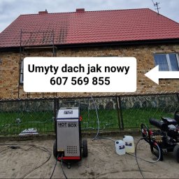 Dariusz Lewandowski - Częściowo umyty dach z czerwonej dachówki, na tle ceglanego domu. Widoczna myjka ciśnieniowa i napis 'Umyty dach jak nowy' z numerem telefonu.