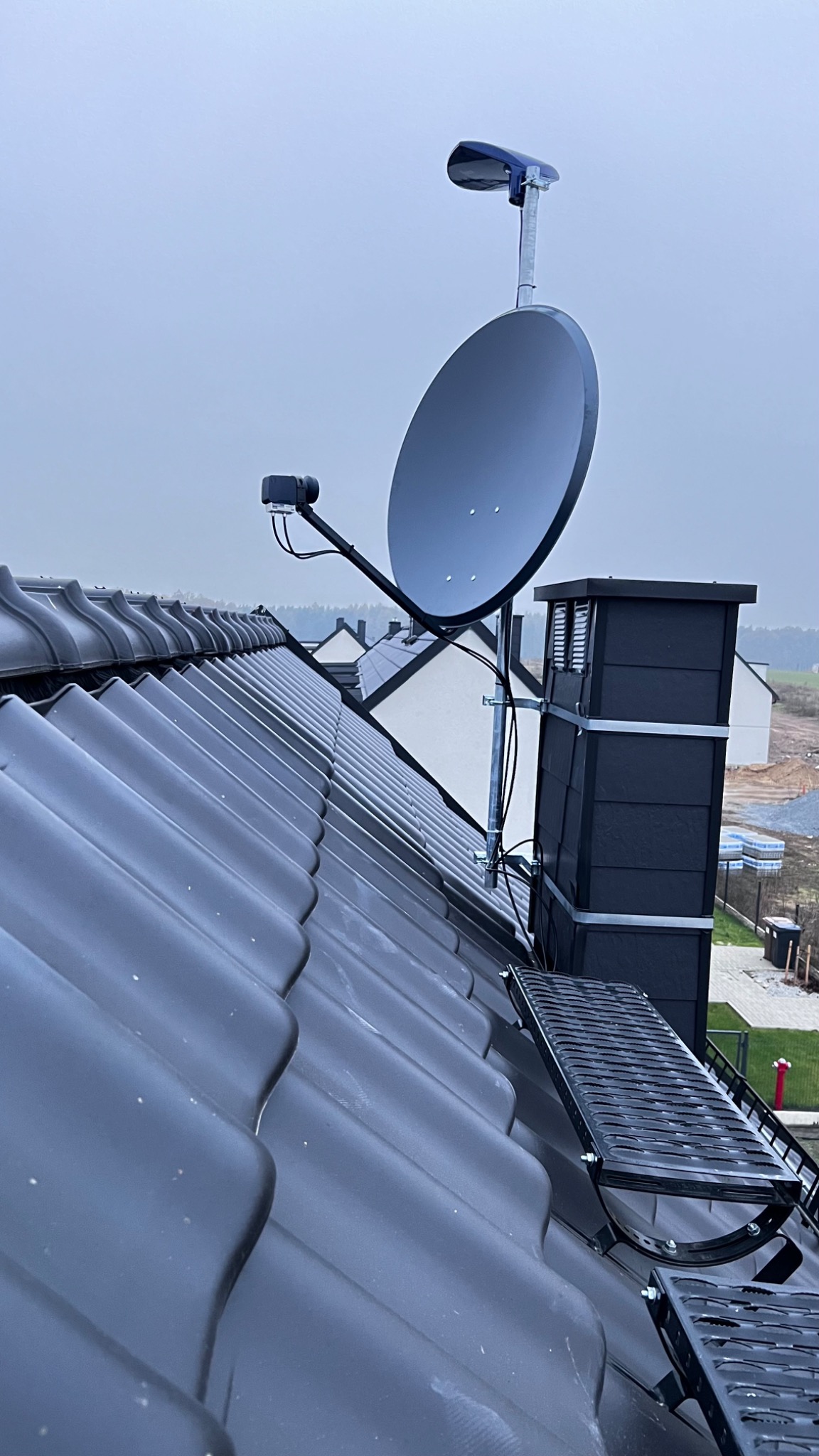 Antena satelitarna zamontowana na dachu domu w Zdzieszowicach, widoczna platforma kominiarska i dodatkowe oświetlenie.