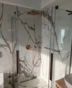 Kabina prysznicowa typu walk-in z marmurowym wzorem na ścianach, złota deszczownica i bateria, brązowe detale wykończeniowe, widoczna umywalka z szafką w tle.