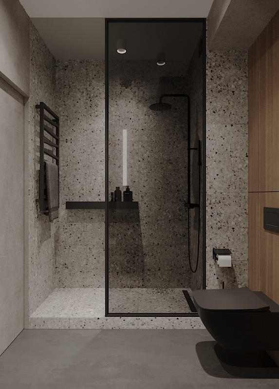 Minimalistyczna łazienka z kabiną prysznicową typu walk-in, czarną armaturą i płytkami imitującymi lastryko na ścianach oraz wiszącą toaletą.