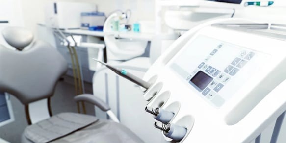 Jasne, nowoczesne wnętrze gabinetu stomatologicznego w Tarnowie z fotelem dentystycznym i panelem sterowania urządzeń.