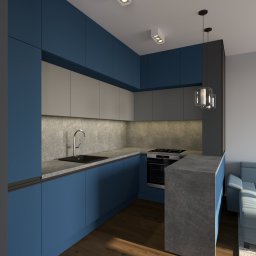 Inovo Design Studio - Wizualizacja kuchni z niebieskimi szafkami, szarym blatem i marmurową ścianą. Widoczny fragment salonu z niebieską sofą. Nowoczesne oświetlenie sufitowe.