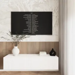 Telewizor z wyświetlonymi napisami końcowymi filmu, umieszczony na tle ściany z tapetą w motywy drzew i drewnianą boazerią. Poniżej biała szafka RTV z wazonem z gałązkami i czarnym, dekoracyjnym...