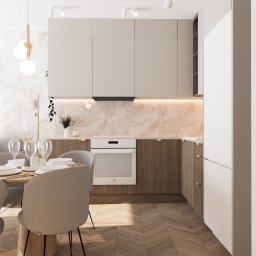 Kwiatkowska Studio - Nowoczesna kuchnia z jasnymi szafkami, marmurowym backsplashiem, drewnianymi frontami dolnych szafek, parkietem w jodełkę i okrągłym stołem z nakryciem.