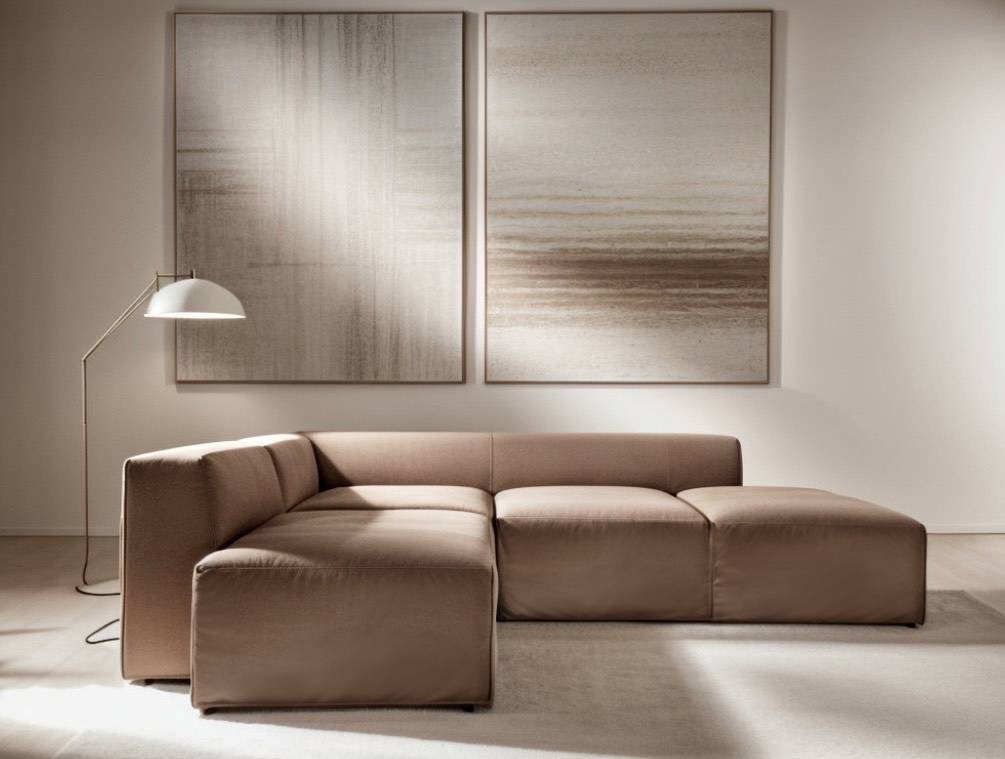 Narożna sofa modułowa w odcieniach beżu, z dwoma abstrakcyjnymi obrazami w tle i lampą podłogową, na jasnym dywanie.