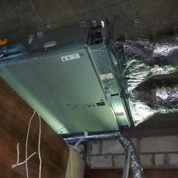 IGLO Mieczysław Klank - Centrala wentylacyjna z rekuperacją zamontowana pod sufitem, widoczne przewody wentylacyjne w izolacji aluminiowej.