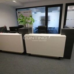 nowoczesna i prosta lada recepcyjna - matowa czerń połączona z połyskującą bielą dodają wnętrzu elegancji