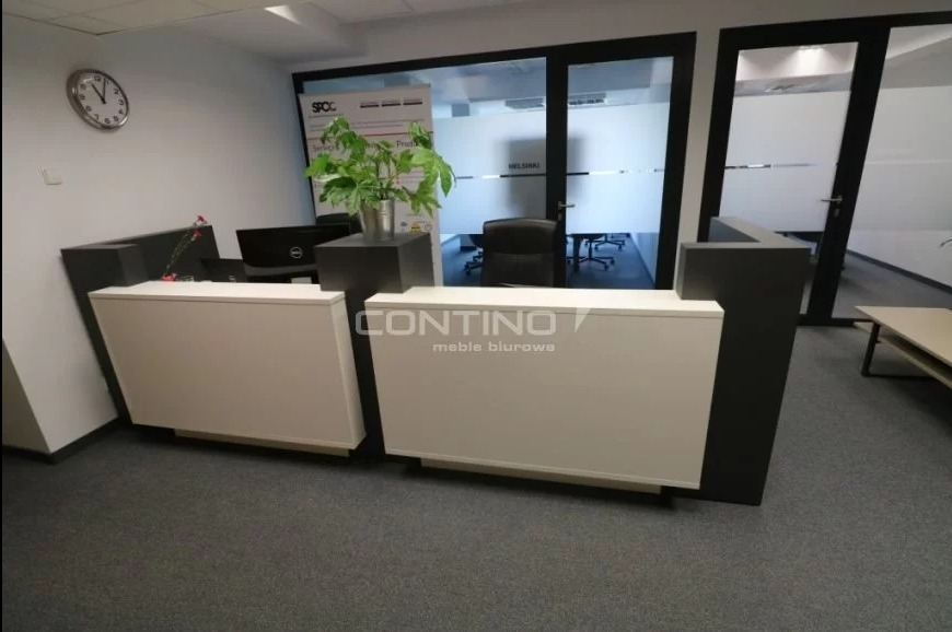 nowoczesna i prosta lada recepcyjna - matowa czerń połączona z połyskującą bielą dodają wnętrzu elegancji